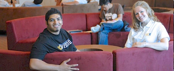 UCR students take a break from studying as they sit on red couches